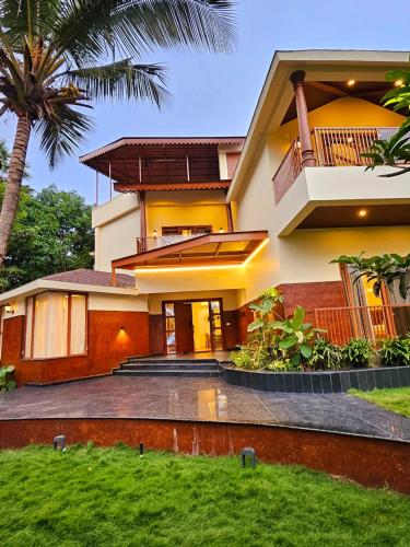 a house with a palm tree in front of it at Savera Seafront in Suratakal
