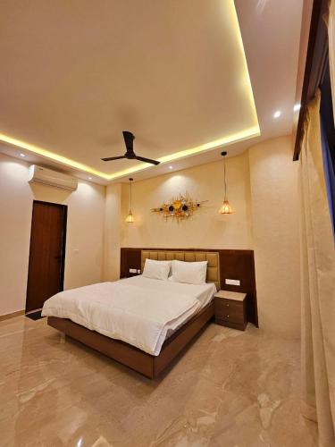 a bedroom with a large bed with a ceiling at Savera Seafront in Suratakal