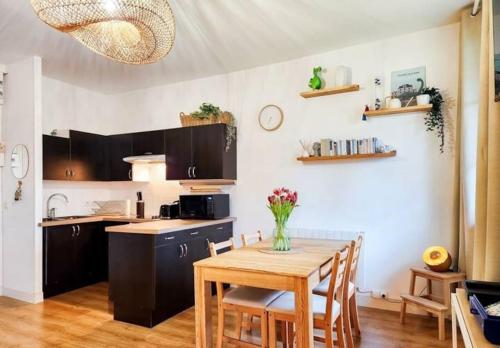 une cuisine et une salle à manger avec une table et des chaises dans l'établissement La Petite Sauvagère, Duplex de charme et cosy, à Villers-sur-Mer