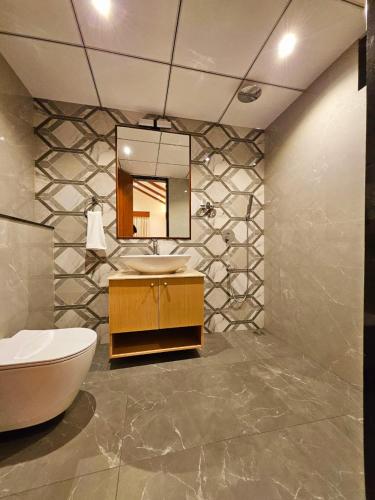 a bathroom with a sink and a mirror at Savera Seafront in Suratakal