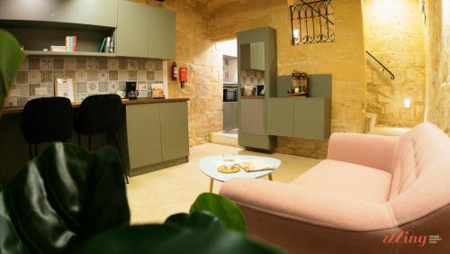 a living room with two chairs and a table at A unique 400-year-old, modern Maltese home in Birgu