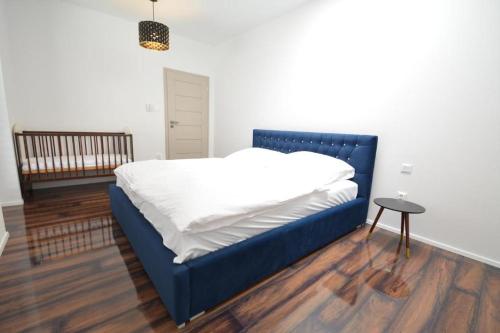 a blue bed in a room with a table at Apartments Sered in Seredʼ