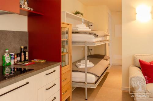 a small room with a bunk bed and a kitchen at Appartamenti La Piazzetta in Sirmione
