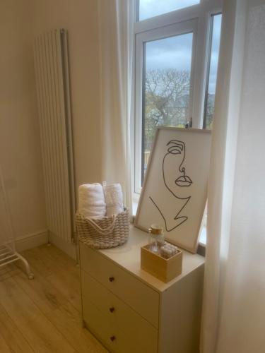 Luxury en-suite in modern house في Catford: حمام به مرآة وخزانة فيها لوحة