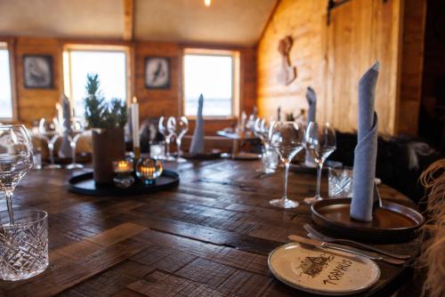 una larga mesa de madera con copas de vino. en Torfhús Retreat en Selfoss