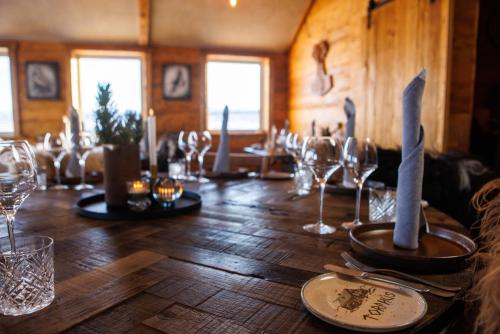 una larga mesa de madera con copas de vino. en Torfhús Retreat, en Selfoss