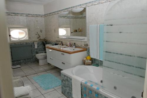 y baño con bañera, lavabo y aseo. en L'Orchidée, en Ginestas