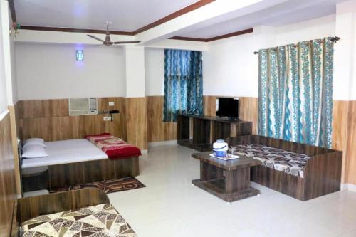 a room with a bed and a couch and a table at New Jain Residency Inn Madhya Pradesh in Pachmarhī