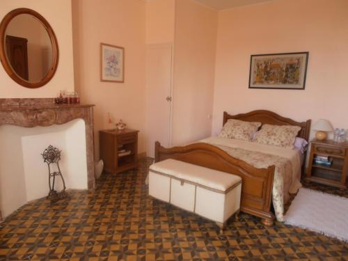 a bedroom with a bed and a mirror at L'Orchidée in Ginestas