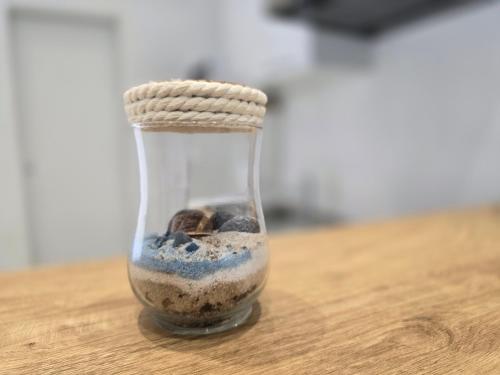 a glass jar filled with sand and rocks on a table at Apartmani Krnić in Šibenik