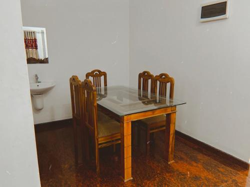 mesa de comedor con sillas y fregadero en Thevitisvillas, en Sultan Bathery