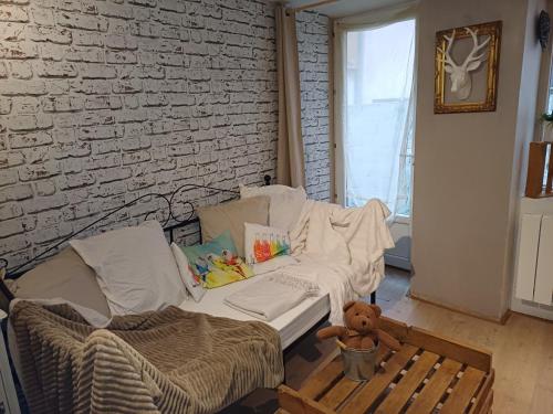 een woonkamer met een bank en een teddybeer bij LE GITE in Colmar