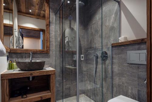 a bathroom with a glass shower with a sink at Madame Vacances Chalet Arda in Le Joseray