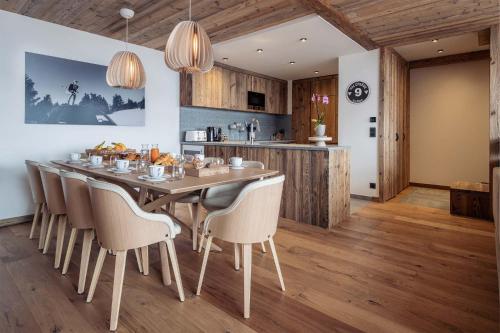 une cuisine et une salle à manger avec une table et des chaises dans l'établissement Madame Vacances Chalet Arda, à Le Joseray