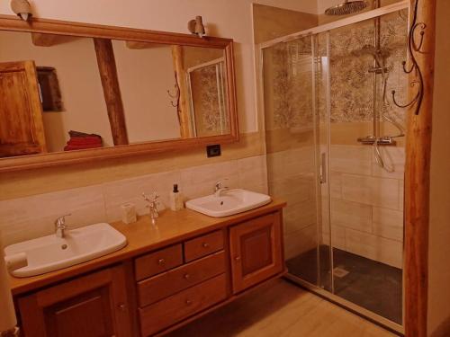 une salle de bain avec deux lavabos et une douche dans l'établissement La Maison du Coeur - Family Holiday, à Oulx