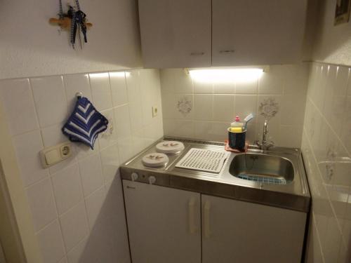 une petite cuisine avec évier et comptoir dans l'établissement Ferienwohnung 'ole Bäckerei', à Delve