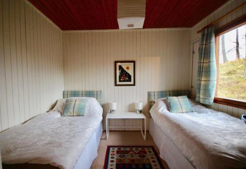 a bedroom with two beds and a window at Woodland Retreats in Fort William