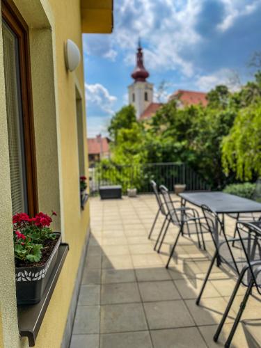 a patio with tables and chairs on a balcony at Slunečný Penzion in Tasovice
