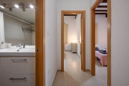 a bathroom with a sink and a mirror and a hallway at AT137 Abadia in Torredembarra