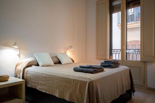 a bedroom with a bed with towels on it at AT137 Abadia in Torredembarra