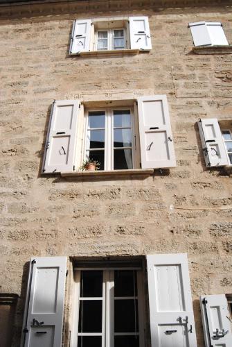 ペズナにあるPézenas appartement coeur historiqueの白い窓と窓のあるレンガ造りの建物
