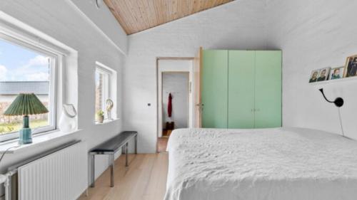 1 dormitorio con cama, escritorio y ventana en Hjertevarm Oase: Harmoni og højt til loftet en Morud