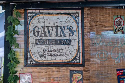 a sign on the side of a brick wall with graffiti at Bay Area Lodge in Coron