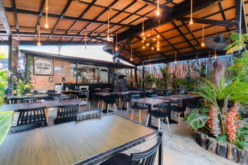 a restaurant with tables and chairs and plants at Bay Area Lodge in Coron