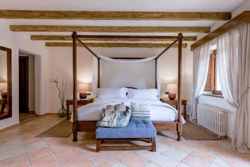 a bedroom with a canopy bed and a blue chair at Ratxó Retreat Hotel, member of Meliá Collection in Puigpunyent