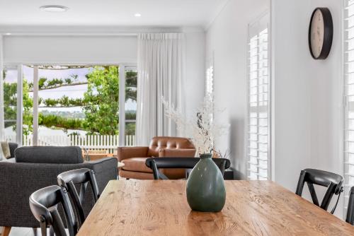 a vase sitting on a wooden table in a living room at Hestia Villa - Luxury Retreat near CBD and Grammar in Toowoomba