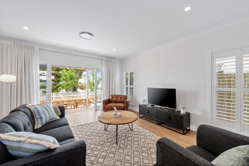 a living room with two couches and a table at Hestia Villa - Luxury Retreat near CBD and Grammar in Toowoomba