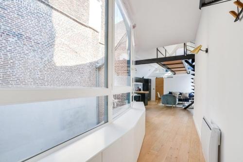 una oficina con una pared de ladrillo y una ventana grande en Lille Centre - Superb 60m2 2bed apartment !, en Lille