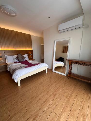 a bedroom with a bed and a large mirror at CasaDel Beach House in Mabini