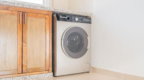 a washing machine in a kitchen next to a cabinet at Airport Apartment M&A in Nador
