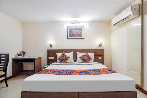 1 dormitorio con 1 cama grande y escritorio en FabHotel Amman en Agra