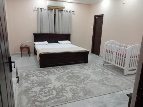um quarto com uma cama, 2 berços e um tapete em 2-Bedroom Elegant and Spacious AC Apartment only for families, Prime Location, Just 100m from Main Road! em Hyderabad