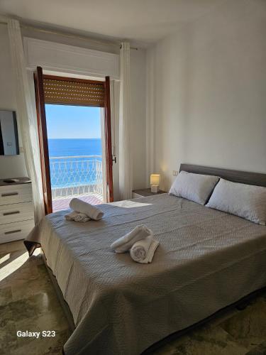 a bedroom with a large bed with towels on it at BAGLIO SUL MARE Letojanni Taormina in Letojanni