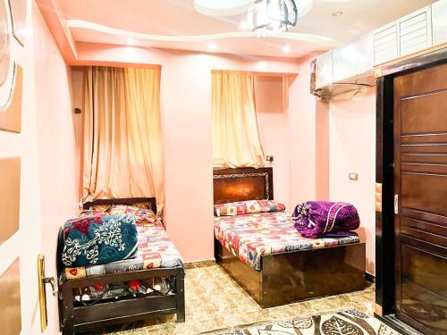 een slaapkamer met 2 bedden en een bank. bij شقة مميزة بجوار كورنيش النيل اسوان - عائلات فقط in Aswan