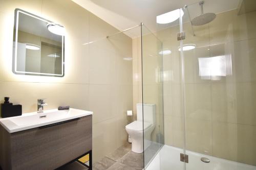 a bathroom with a toilet and a glass shower at Stunning 2 bed apartment in London