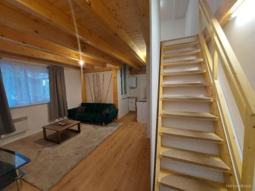 escalera en una sala de estar con sofá verde en Cottage vibe apartment en Komárov