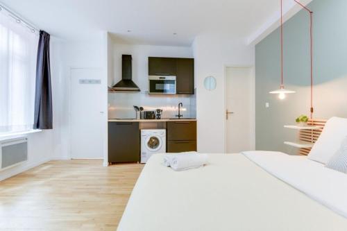 - une chambre blanche avec un lit blanc et une cuisine dans l'établissement Lille Centre - Nice studio, à Lille