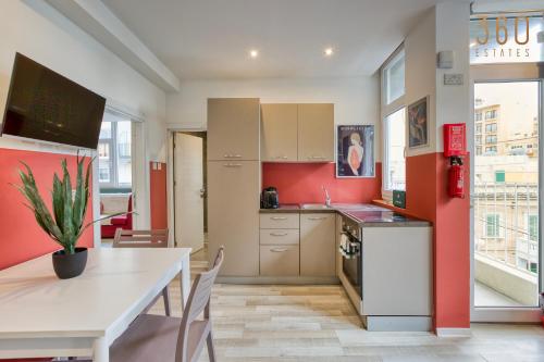 a kitchen with a table and a dining room at Modern Paceville Suites with WIFI & AC by 360 Estates in Paceville