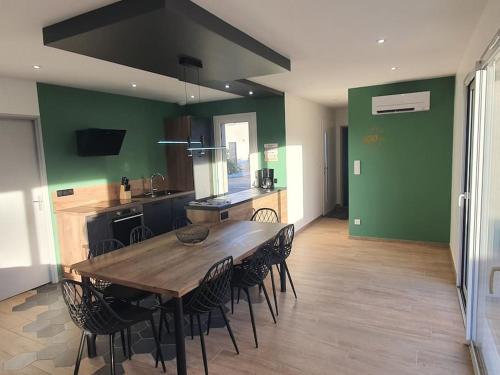 une grande cuisine avec une table et des chaises en bois dans l'établissement Maison à thème le Mans 66, à Guécélard