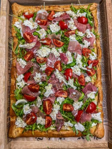 a pizza with tomatoes and cheese on a table at Slunečný Penzion in Tasovice