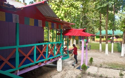 a boy standing in front of a play house at Leo Jungle Retreat by StayApart , Jaldapara in Mādāri Hāt