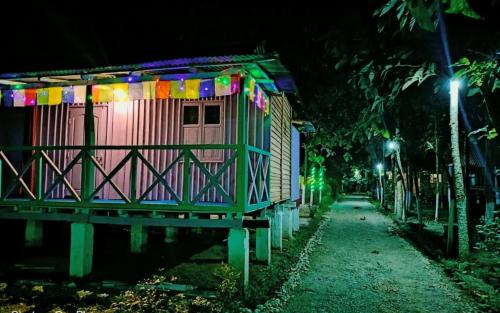 a small house with colorful lights on it at night at Leo Jungle Retreat by StayApart , Jaldapara in Mādāri Hāt