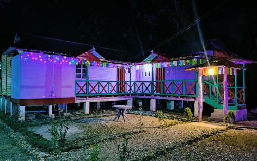 a house with purple lights on it at night at Leo Jungle Retreat by StayApart , Jaldapara in Mādāri Hāt