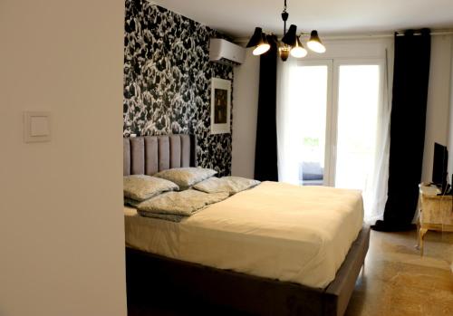 Schlafzimmer mit einem Bett mit einer schwarz-weißen Wand in der Unterkunft Luxurious studio apartment close to the beach and airport in Porto Rafti