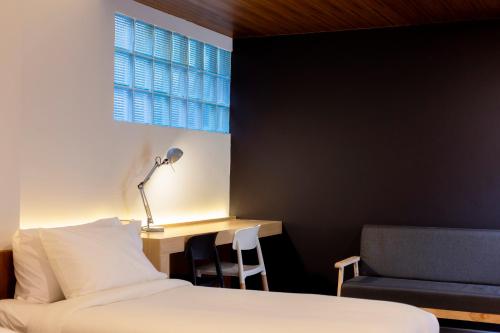 a bedroom with a bed and a desk and a chair at Karpenter Lampang in Lampang
