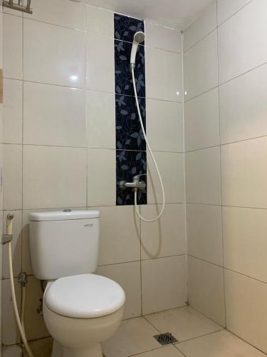 a bathroom with a toilet and a shower at Pakuwon ORCHARD Apartment by Dovey in Surabaya
